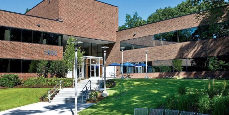A building with grass and trees in front of it